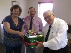 Director of Nursing Mrs. Alicia Trimingham-Turl receives the Gift Hamper from Mr. Bob Sellers and Mr. Jim Tyrell for the Order of St Johns